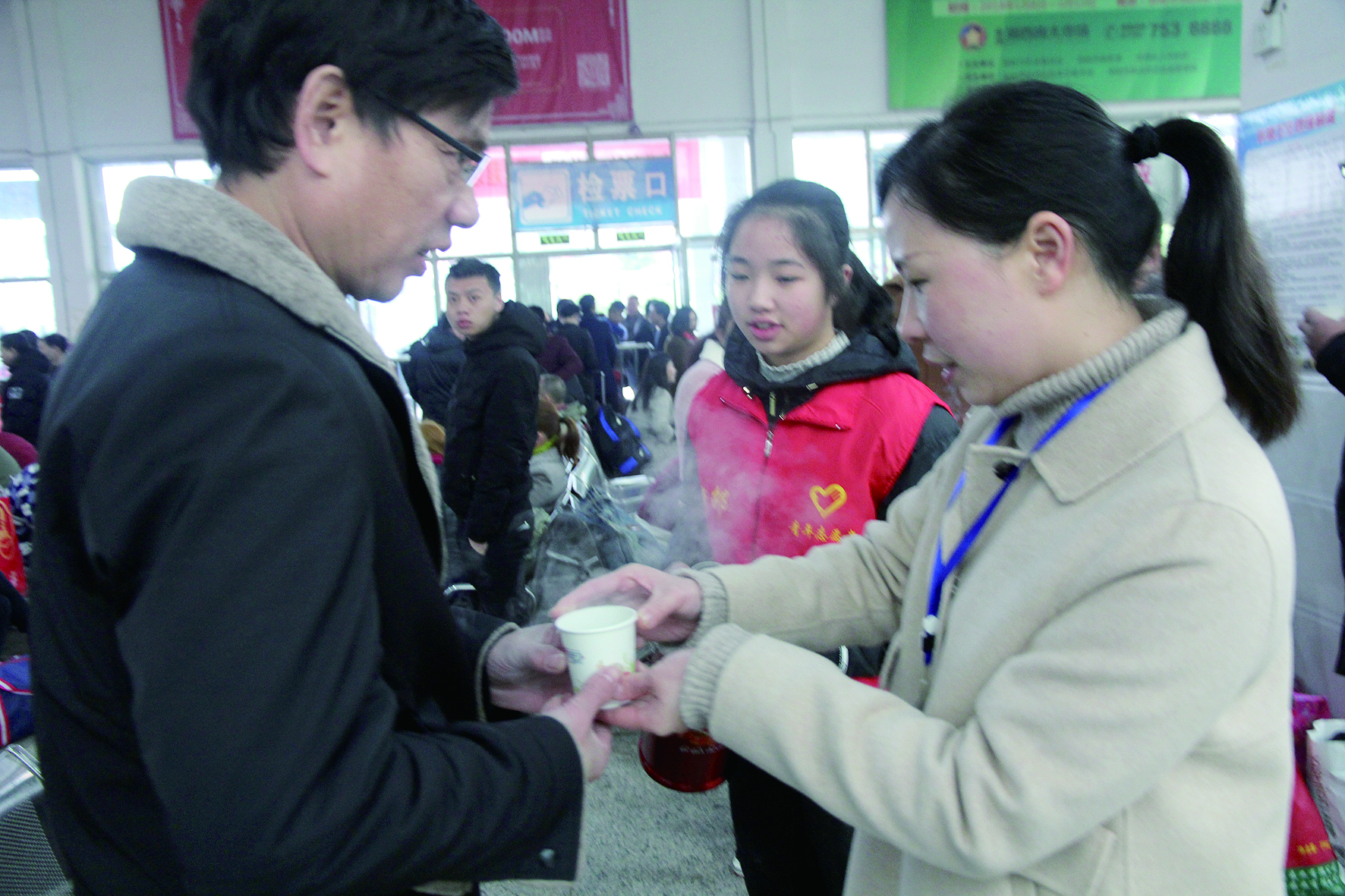 母女服務(wù)春運(yùn) 2月13日，記者在新邵分公司汽車站看到，該分公司安全科副科長(zhǎng)李喜梅與其在新邵一中初中部1701班就讀女兒劉嘉怡在車站擔(dān)當(dāng)志愿者。李喜梅在候車室耐心為旅客釋疑解惑，劉嘉怡為旅客遞上一杯杯熱茶，有時(shí)母女也相互合作，其樂融融。 祖冠 攝影報(bào)道